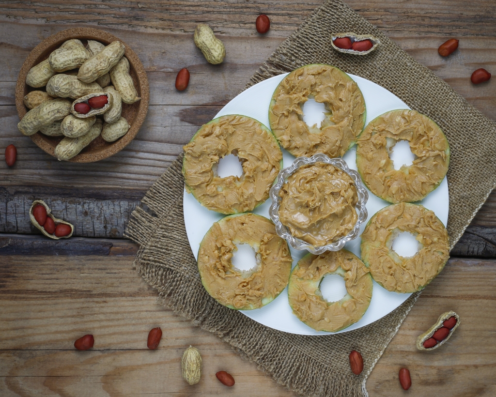 Healthy sandwich. Green apple rounds with peanut butter and red